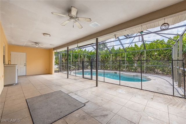outdoor pool with ceiling fan, a lanai, and a patio area