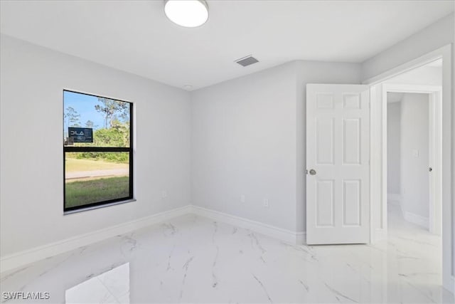 unfurnished room featuring baseboards, visible vents, and marble finish floor