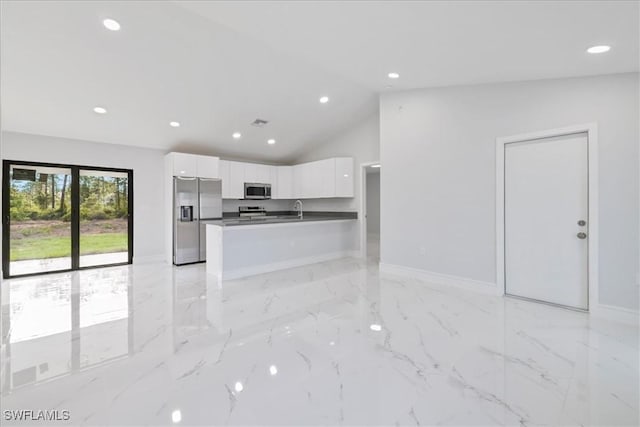 kitchen featuring recessed lighting, white cabinetry, a sink, vaulted ceiling, and stainless steel appliances