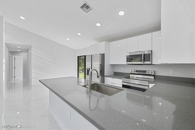 kitchen featuring visible vents, a sink, marble finish floor, stainless steel appliances, and white cabinetry