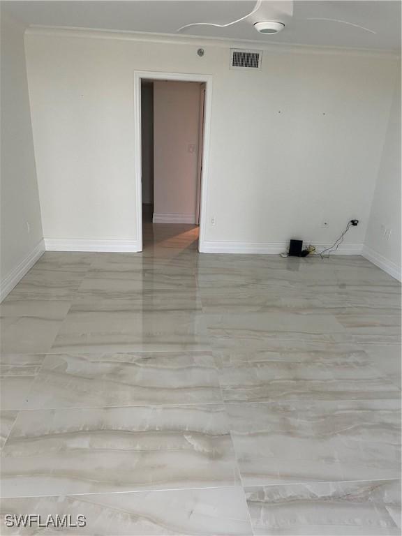 unfurnished room with ornamental molding and baseboards