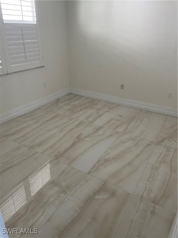 unfurnished room with baseboards