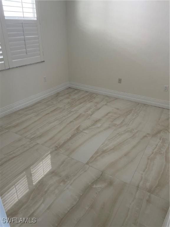 unfurnished room featuring baseboards