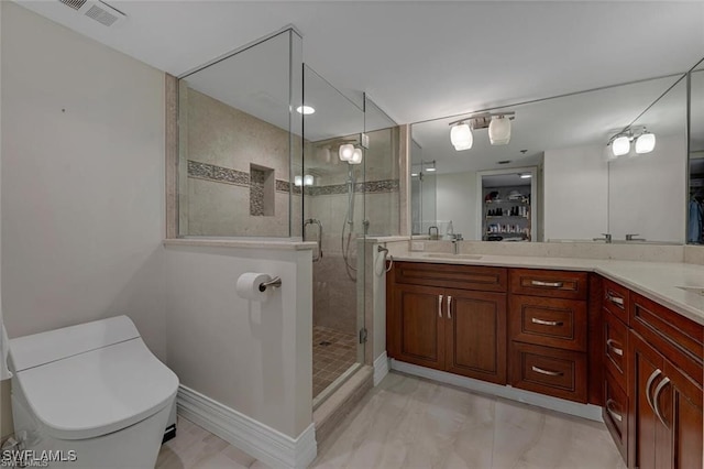 bathroom featuring a shower stall, vanity, and a walk in closet