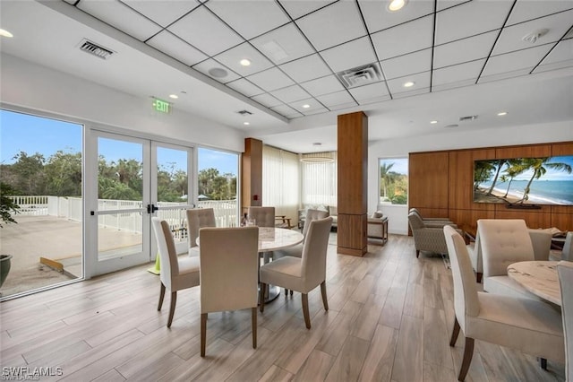 dining space featuring light wood-style flooring, french doors, recessed lighting, and a paneled ceiling