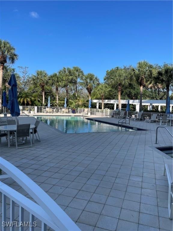 community pool featuring a patio area and fence
