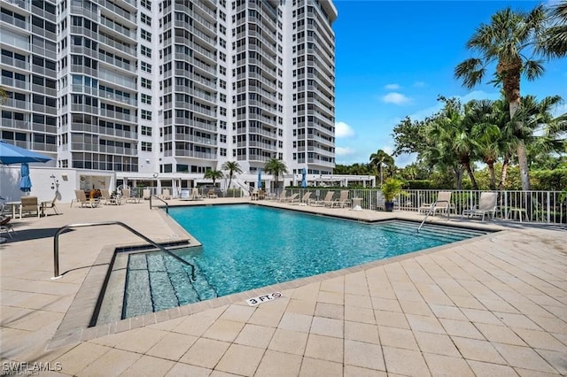 community pool featuring fence and a patio area