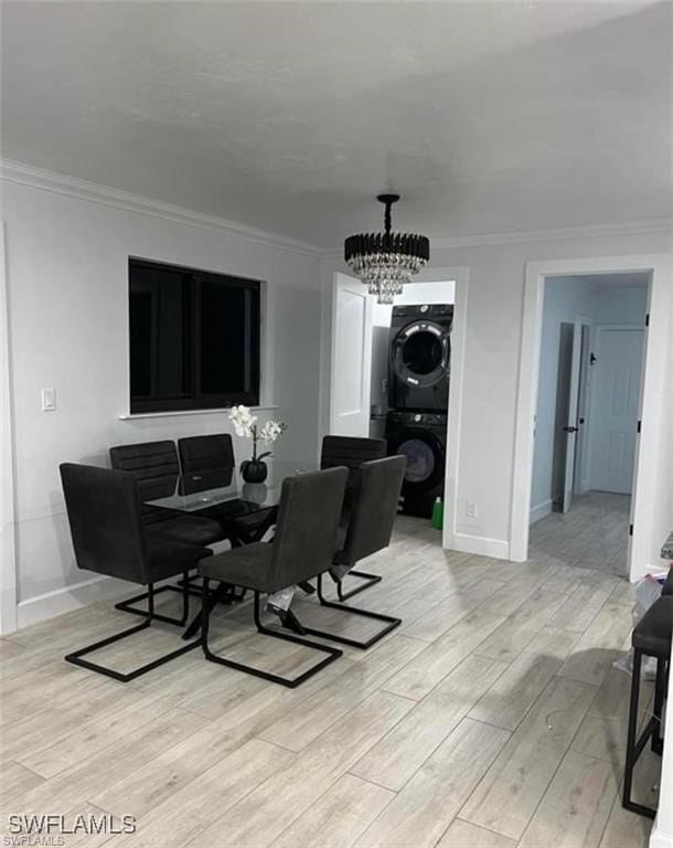 3650 1st Ave SW, Naples, FL 34117 - dining area featuring a notable chandelier, baseboards, ornamental molding, light wood finished floors, and stacked washer / drying machine