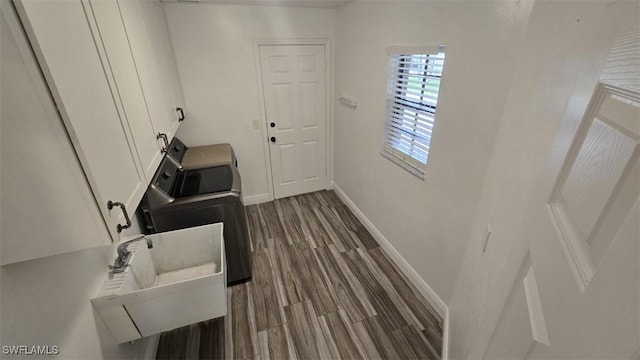 7311 Sean Ln, North Fort Myers, FL 33917 - laundry area with baseboards, dark wood-style floors, and cabinet space