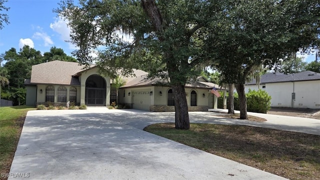 7311 Sean Ln, North Fort Myers, FL 33917 - view of front of house with curved driveway, stucco siding, and an attached garage