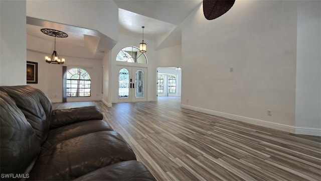 7311 Sean Ln, North Fort Myers, FL 33917 - living room featuring plenty of natural light, wood finished floors, a chandelier, baseboards, and high vaulted ceiling