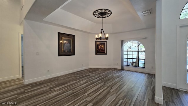 7311 Sean Ln, North Fort Myers, FL 33917 - unfurnished room featuring dark wood finished floors, a chandelier, a raised ceiling, and healthy amount of natural light