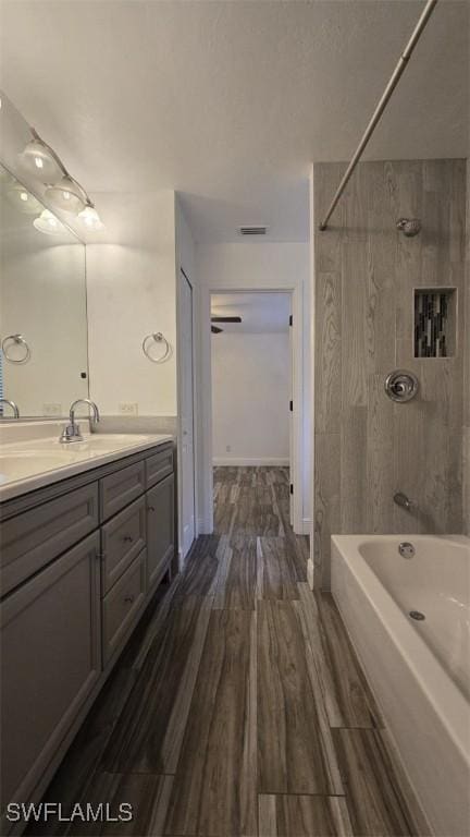 7311 Sean Ln, North Fort Myers, FL 33917 - bathroom featuring vanity, wood finished floors, and tub / shower combination