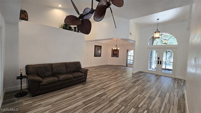 7311 Sean Ln, North Fort Myers, FL 33917 - living area featuring french doors, wood finished floors, a towering ceiling, baseboards, and ceiling fan