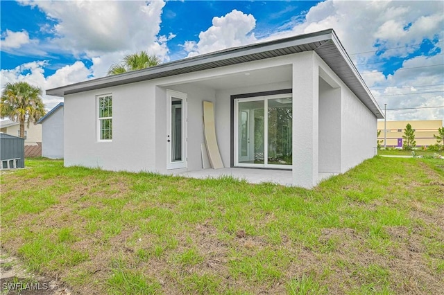 2174 Highland Ave, Fort Myers, FL 33916 - back of house with stucco siding, a lawn, and a patio area