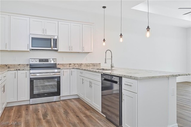 2174 Highland Ave, Fort Myers, FL 33916 - kitchen featuring stainless steel appliances, a peninsula, a sink, and wood finished floors