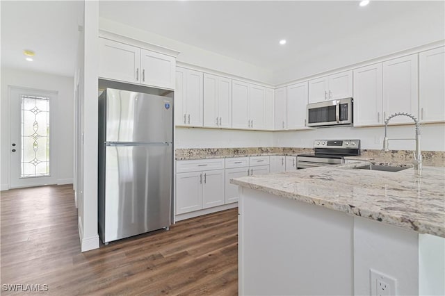 2174 Highland Ave, Fort Myers, FL 33916 - kitchen featuring appliances with stainless steel finishes, a sink, dark wood-style floors, white cabinets, and light stone countertops