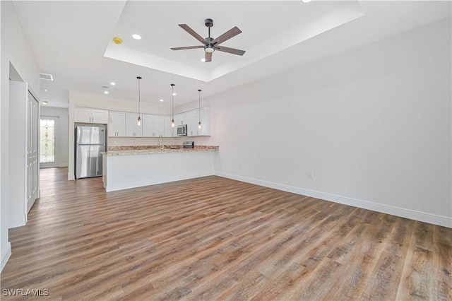 2174 Highland Ave, Fort Myers, FL 33916 - unfurnished living room featuring a tray ceiling, ceiling fan, wood finished floors, recessed lighting, and baseboards