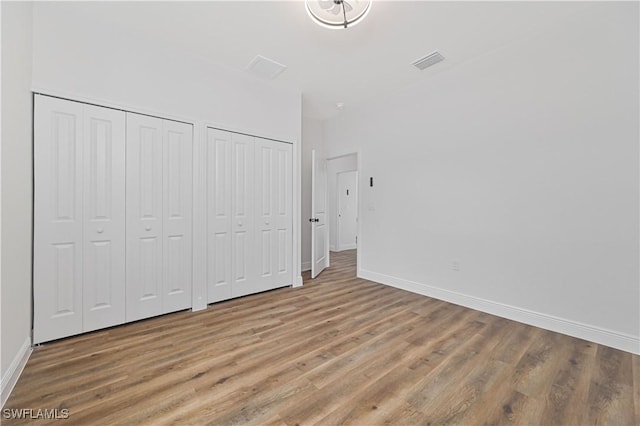 2174 Highland Ave, Fort Myers, FL 33916 - unfurnished bedroom with light wood finished floors, baseboards, and multiple closets