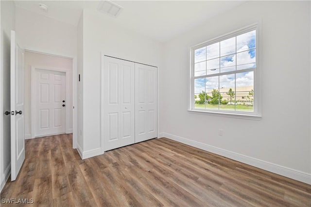 2174 Highland Ave, Fort Myers, FL 33916 - unfurnished bedroom with wood finished floors, baseboards, and a closet