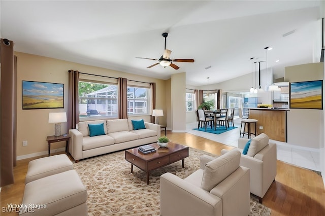 6731 Blake Pledger Ct, North Fort Myers, FL 33917 - living room with a ceiling fan, baseboards, vaulted ceiling, and a wealth of natural light