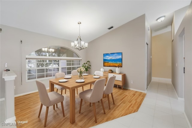 6731 Blake Pledger Ct, North Fort Myers, FL 33917 - dining space with visible vents, baseboards, light wood-type flooring, a notable chandelier, and vaulted ceiling