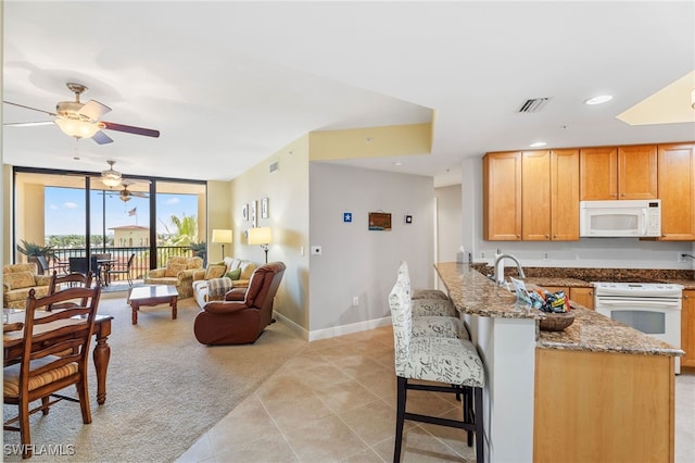 5781 Cape Harbour Dr Unit 610, Cape Coral, FL 33914 - kitchen with a peninsula, white appliances, visible vents, ceiling fan, and floor to ceiling windows