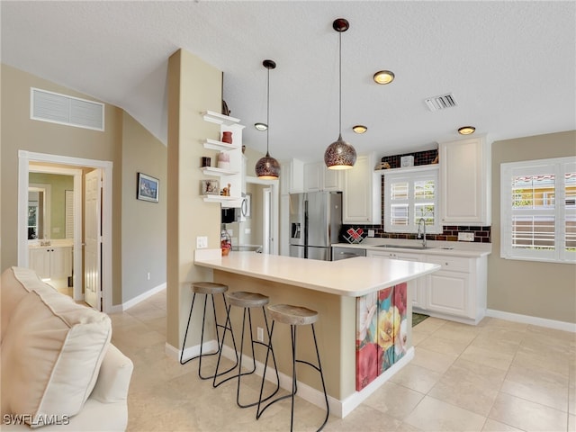 28902 Vermillion Ln, Bonita Springs, FL 34135 - kitchen with stainless steel refrigerator with ice dispenser, a kitchen bar, open shelves, light countertops, and light tile patterned flooring