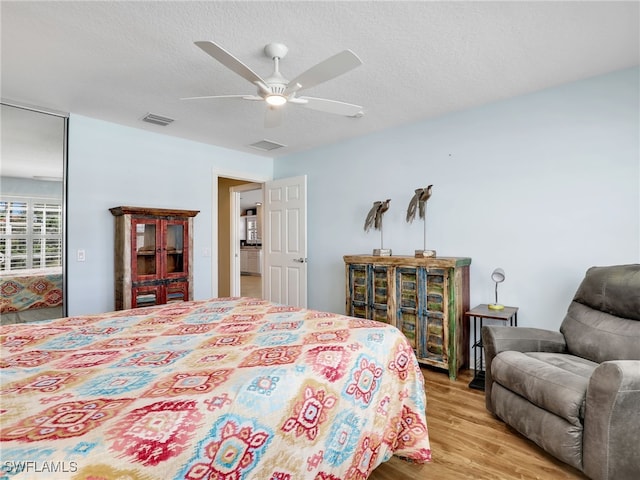 28902 Vermillion Ln, Bonita Springs, FL 34135 - bedroom featuring light wood-style flooring, ceiling fan, and a textured ceiling