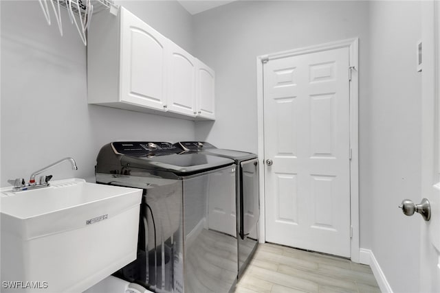 14831 Blackbird Ln, Fort Myers, FL 33919 - washroom featuring cabinet space, independent washer and dryer, light wood-style floors, and baseboards