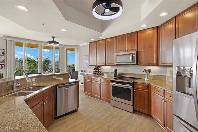 3414 Hancock Bridge Pkwy Unit 502, North Fort Myers, FL 33903 - kitchen with appliances with stainless steel finishes, a sink, light wood-style flooring, a raised ceiling, and brown cabinetry