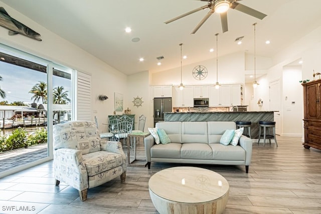 living area featuring visible vents, high vaulted ceiling, recessed lighting, a ceiling fan, and light wood-style flooring