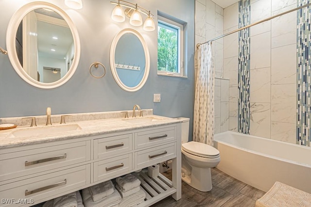 bathroom featuring a sink, shower / bath combo with shower curtain, toilet, and wood finished floors