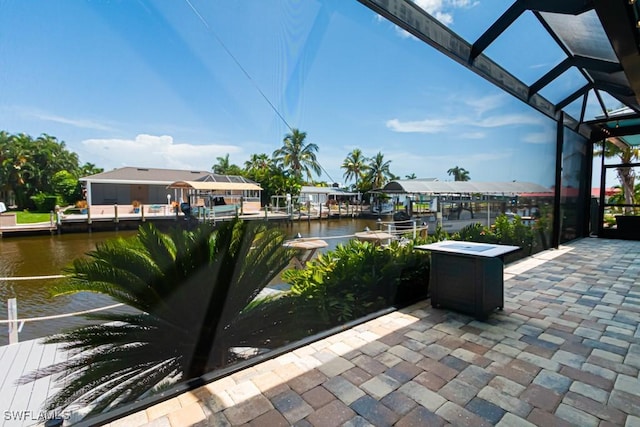 view of patio featuring boat lift, a lanai, a water view, and a dock