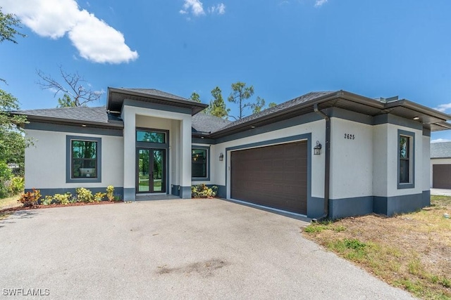 2625 27th Ave NE, Naples, FL 34120 - prairie-style home with stucco siding, an attached garage, and driveway