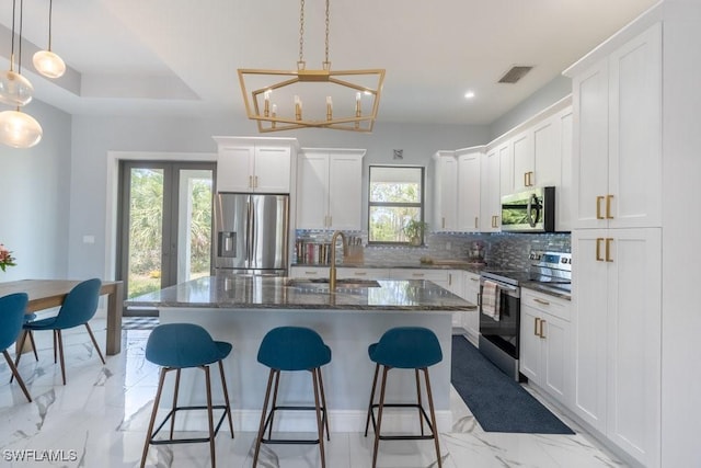 2625 27th Ave NE, Naples, FL 34120 - kitchen with appliances with stainless steel finishes, a sink, backsplash, a breakfast bar, and recessed lighting