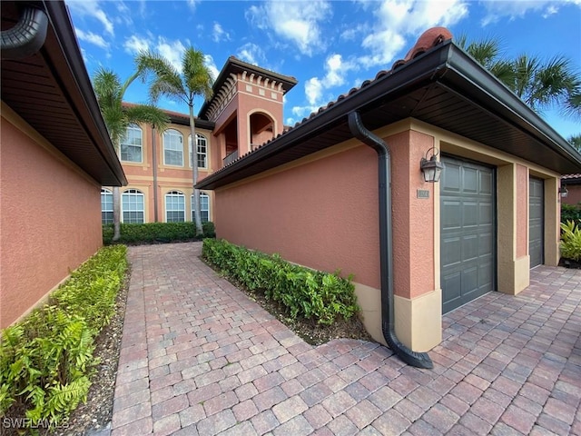 view of home's exterior with stucco siding and a garage