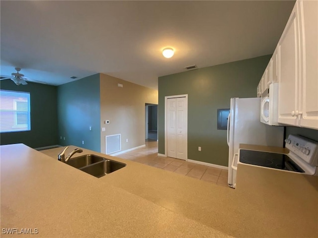 kitchen with white appliances, a sink, a ceiling fan, white cabinets, and light tile patterned floors