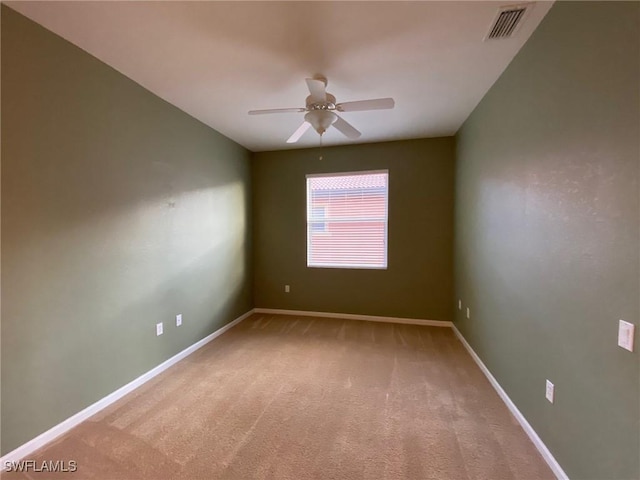 spare room with light carpet, baseboards, and a ceiling fan