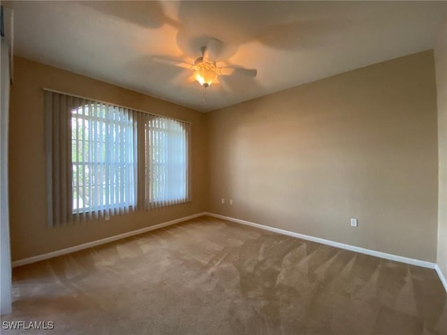 empty room with baseboards, carpet flooring, and a ceiling fan