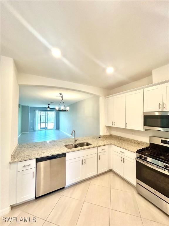 kitchen featuring white cabinetry, appliances with stainless steel finishes, a sink, and light tile patterned floors