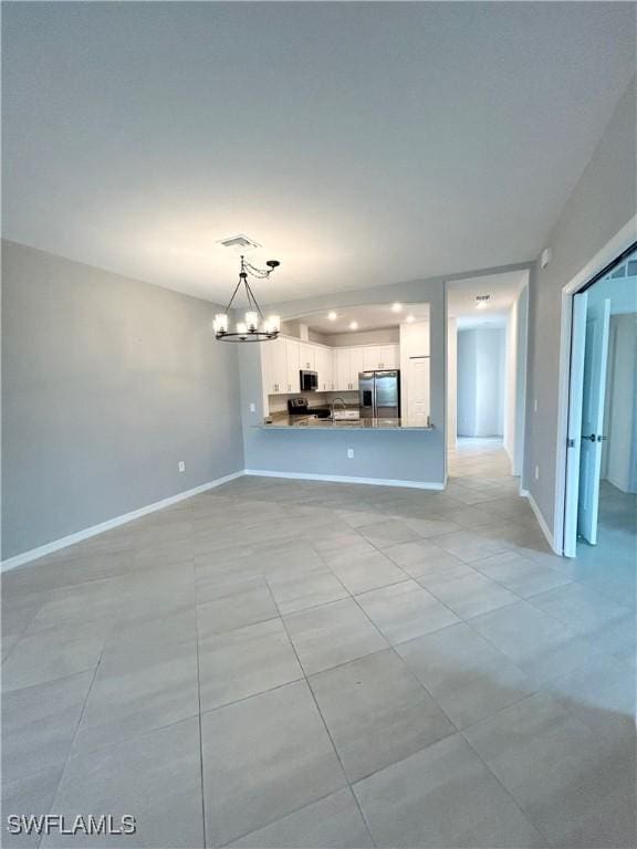 unfurnished living room featuring an inviting chandelier, recessed lighting, baseboards, and light tile patterned floors