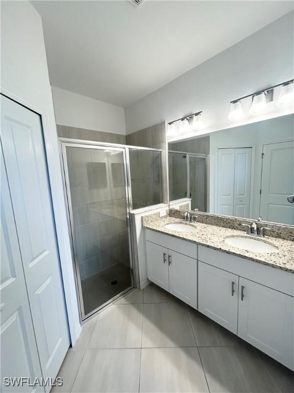 full bathroom with a sink, tile patterned floors, and a shower stall