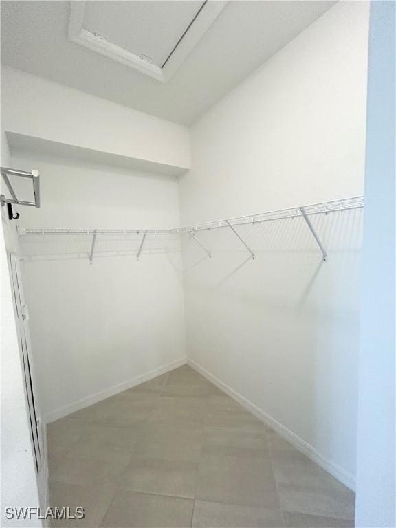 walk in closet featuring attic access
