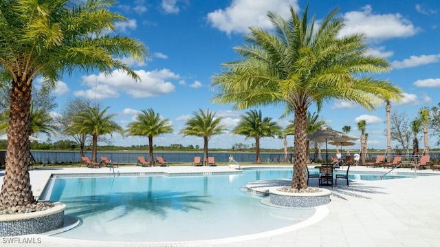 community pool with fence and a patio area