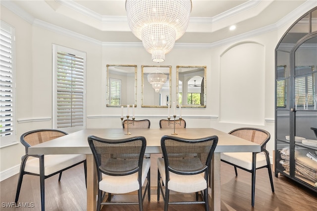 dining space with a raised ceiling, a healthy amount of sunlight, and a notable chandelier