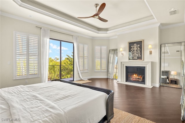 15460 Catalpa Cove Ln, Fort Myers, FL 33908 - bedroom featuring a tray ceiling, wood finished floors, access to outside, a glass covered fireplace, and crown molding
