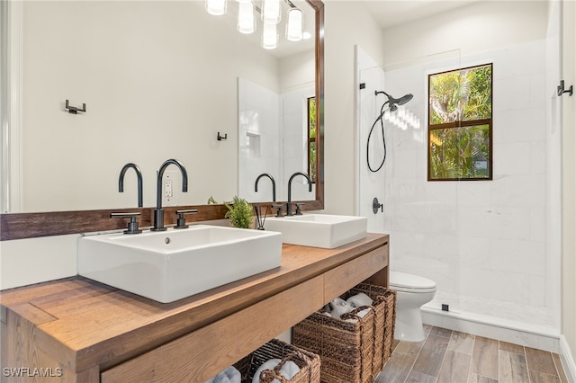 15460 Catalpa Cove Ln, Fort Myers, FL 33908 - bathroom with toilet, a tile shower, double vanity, and wood finished floors