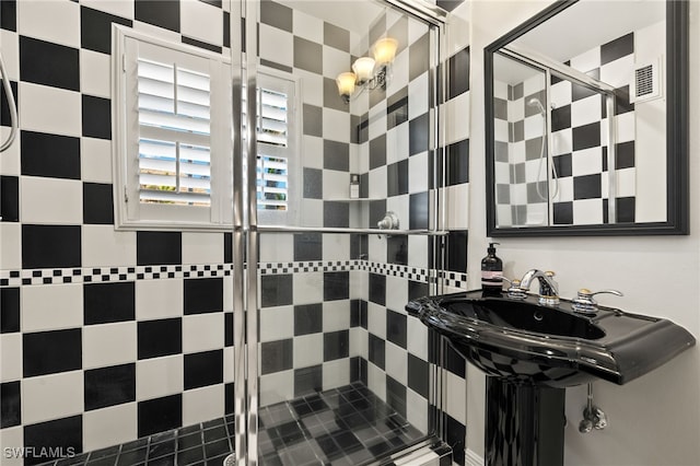 bathroom with a stall shower and visible vents