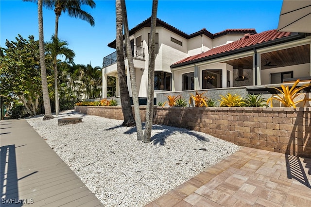15460 Catalpa Cove Ln, Fort Myers, FL 33908 - view of property exterior with a balcony, a tiled roof, and stucco siding